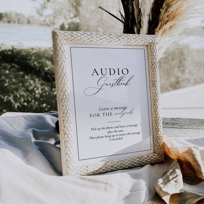 Wicker frame with 'Audio Guestbook' sign on a table outdoors