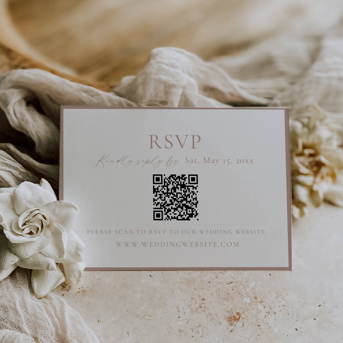 RSVP card with QR code on a textured surface with flowers and fabric