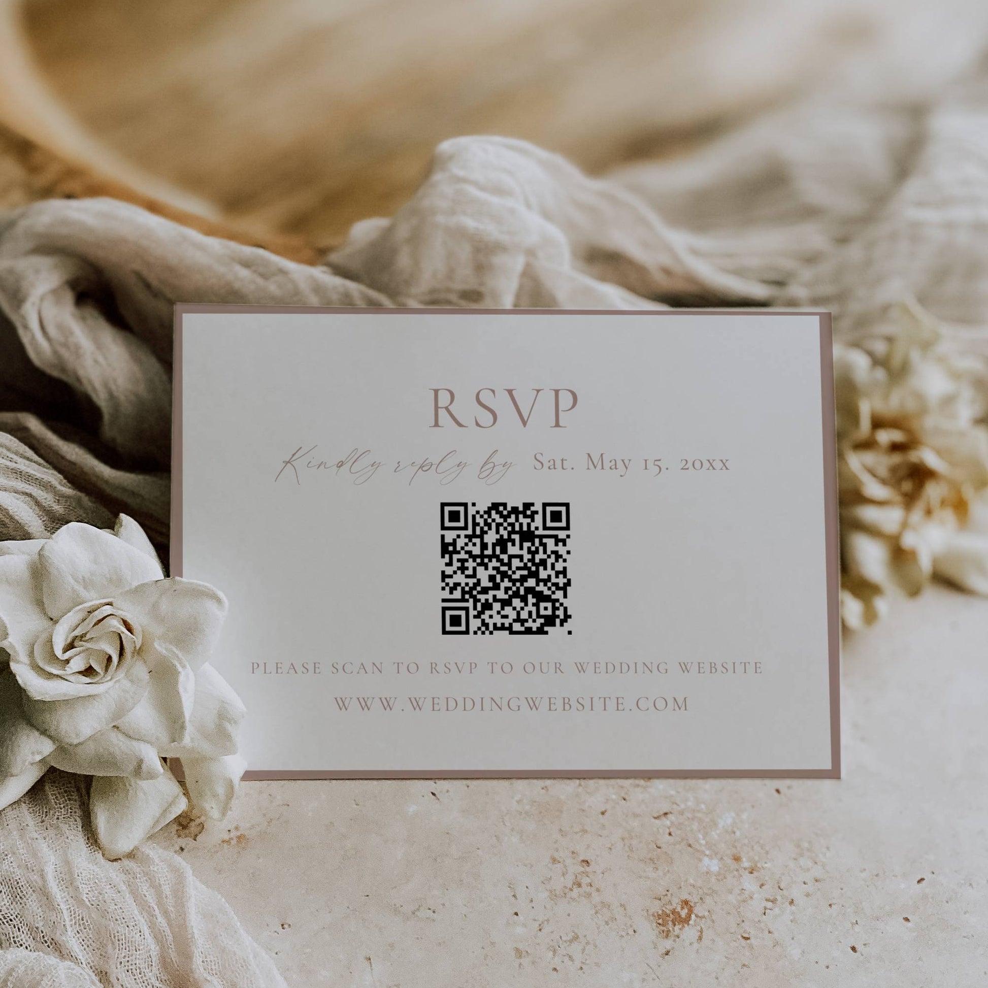 RSVP card with QR code on a textured surface with flowers and fabric