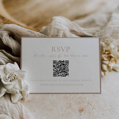 RSVP card with QR code on a textured surface with flowers and fabric