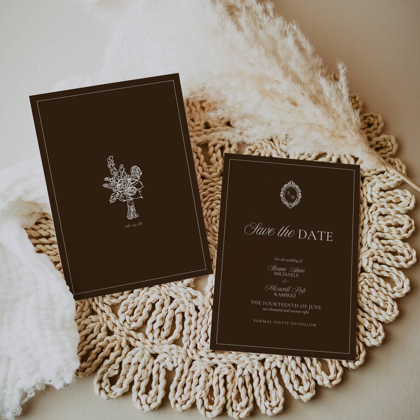Two dark brown 'Save the Date' cards on a textured white surface
