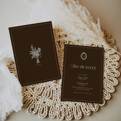 Two dark brown 'Save the Date' cards on a textured white surface