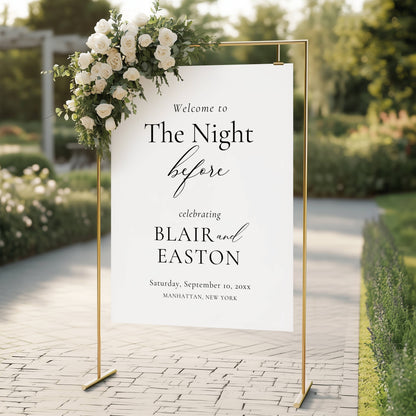 Wedding welcome sign with floral arch in an outdoor setting