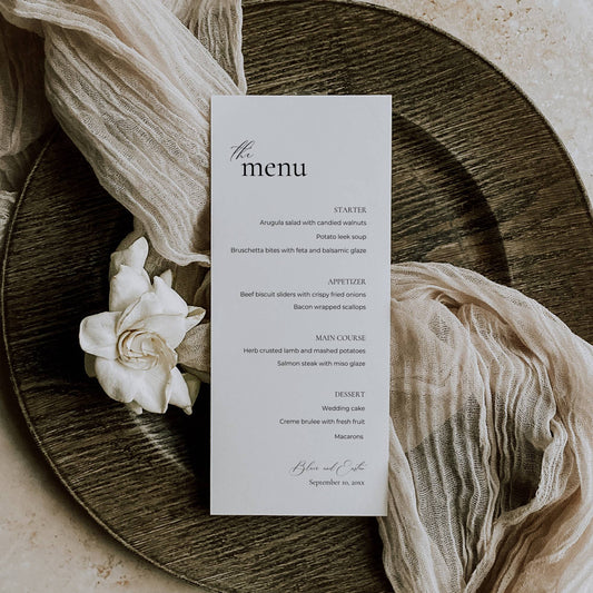 Menu card on a wooden plate with white flowers and fabric