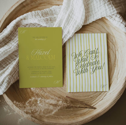 Lime green and yellow-striped wedding invitation cards styled on a wooden tray
