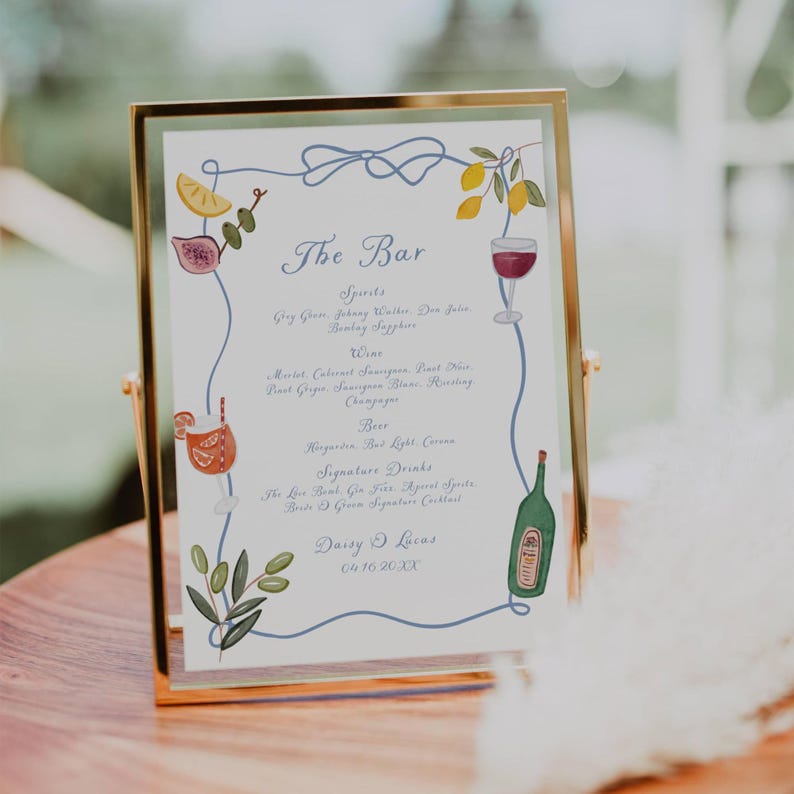 Gold-framed bar menu sign with watercolor drink and fruit illustrations