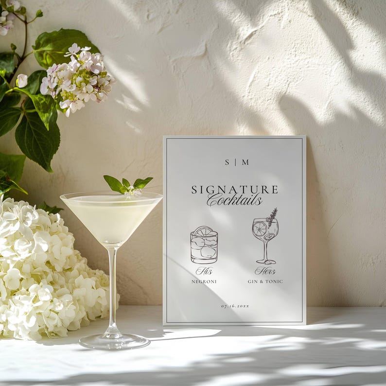 Signature cocktails sign styled with a martini glass, mint garnish, and white flowers