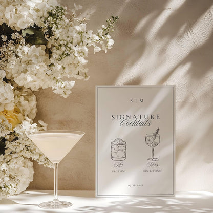Signature cocktails sign beside a pale yellow cocktail with white florals and foliage