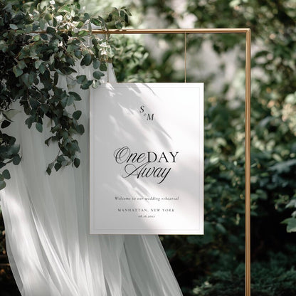 Black and white Old Money rehearsal welcome sign hanging from a gold metal frame with monogram and script