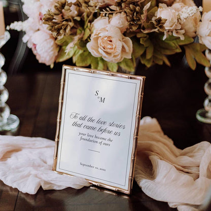 Love Stories Before Ours sign with gold trim styled with flowers and date