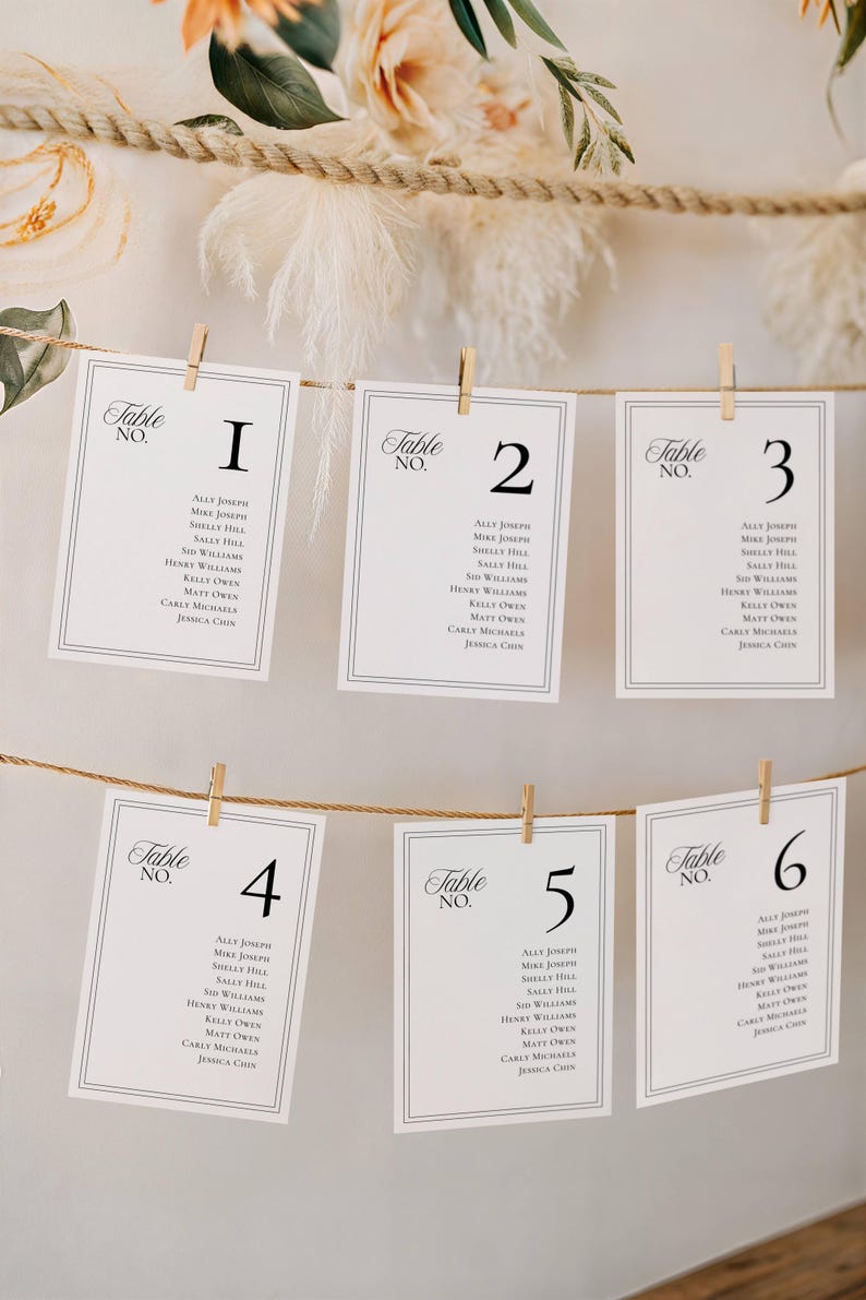 Seating chart cards hanging from jute rope with wooden clothespins