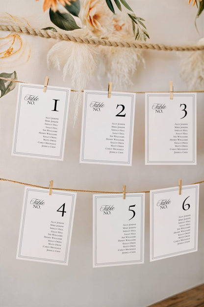 Seating chart cards hanging from jute rope with wooden clothespins