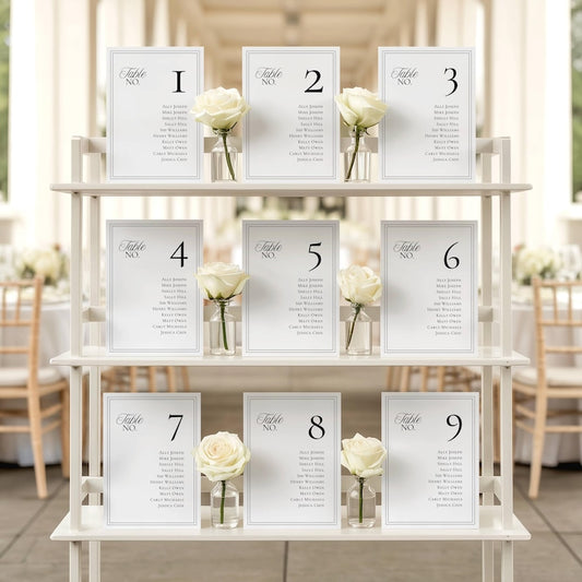Seating chart cards displayed on a three-tiered stand with a single white rose