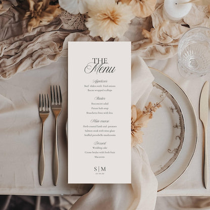 Vertical wedding menu card on off-white paper with black serif and script typography listing appetizers, starters, mains, and desserts, ending with initials S|M and date 10.10.XX