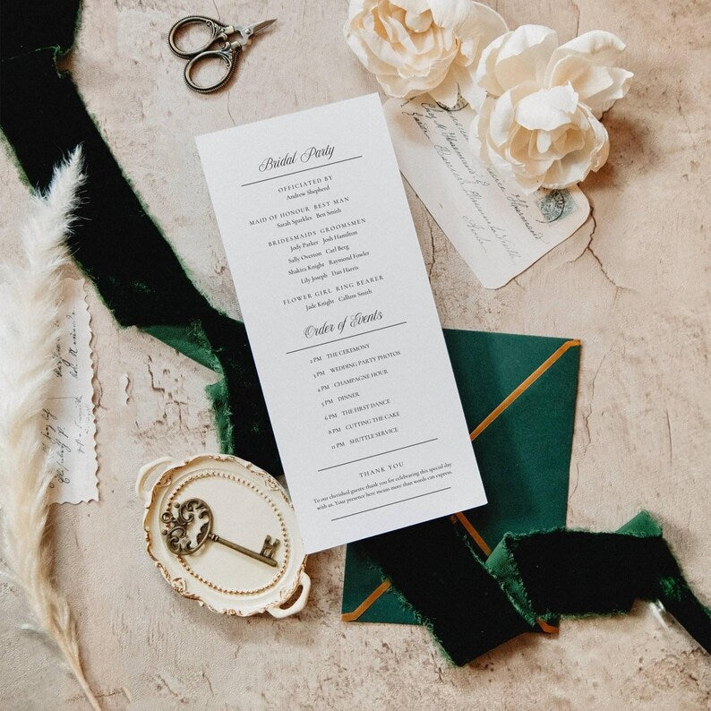 Wedding program template styled flat lay with ivory roses on deep green velvet
