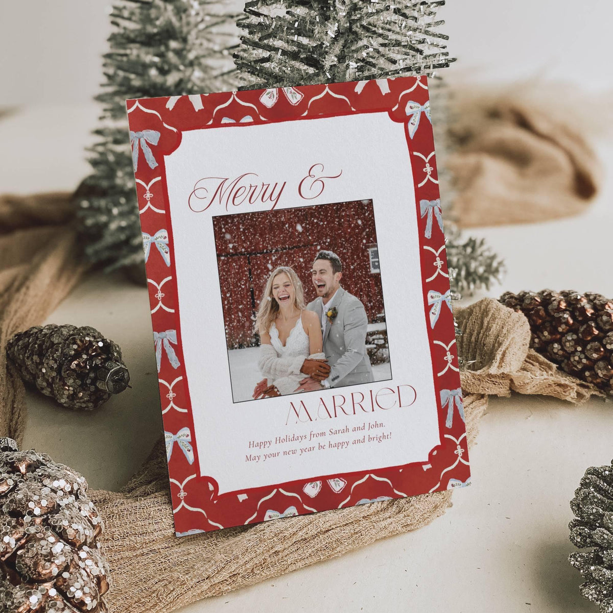 Merry and Married wedding photo Christmas card with festive red and soft blue bow border, styled flat lay