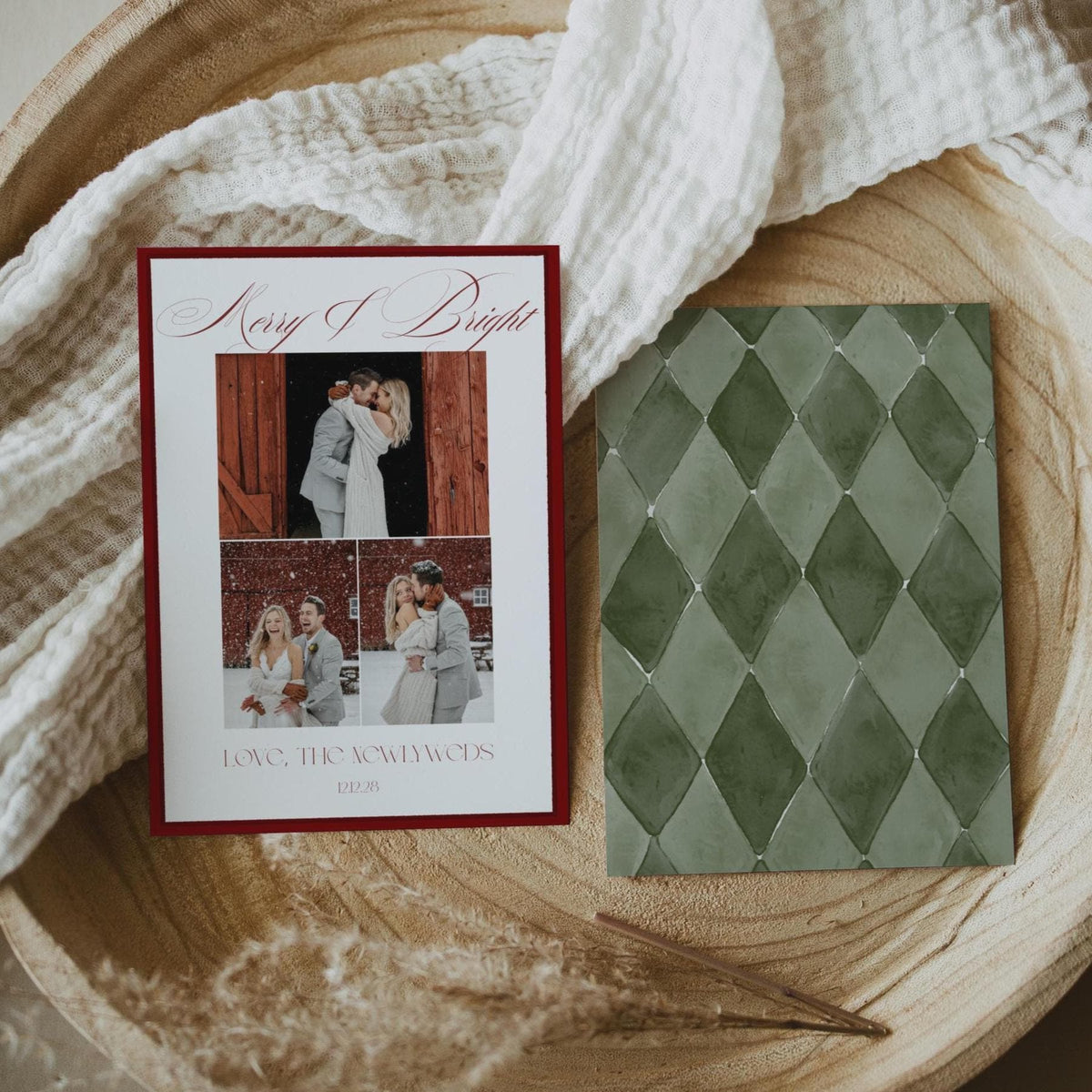 Double-sided 5x7 newlywed Christmas card with burgundy border and green diamond pattern back in a round wooden bowl